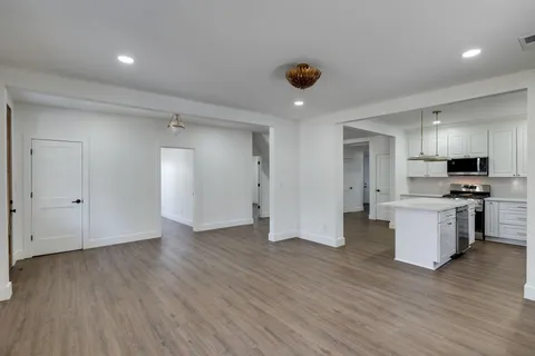 a view of kitchen with stainless steel appliances granite countertop a refrigerator and a stove top oven