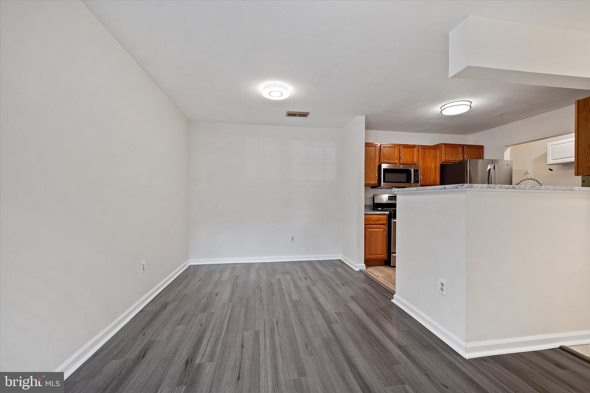 8083 Lacy Drive, Unit 101 Manassas, VA 20109 - Photo 14 of 31 a view of a kitchen with a fridge and wooden floor