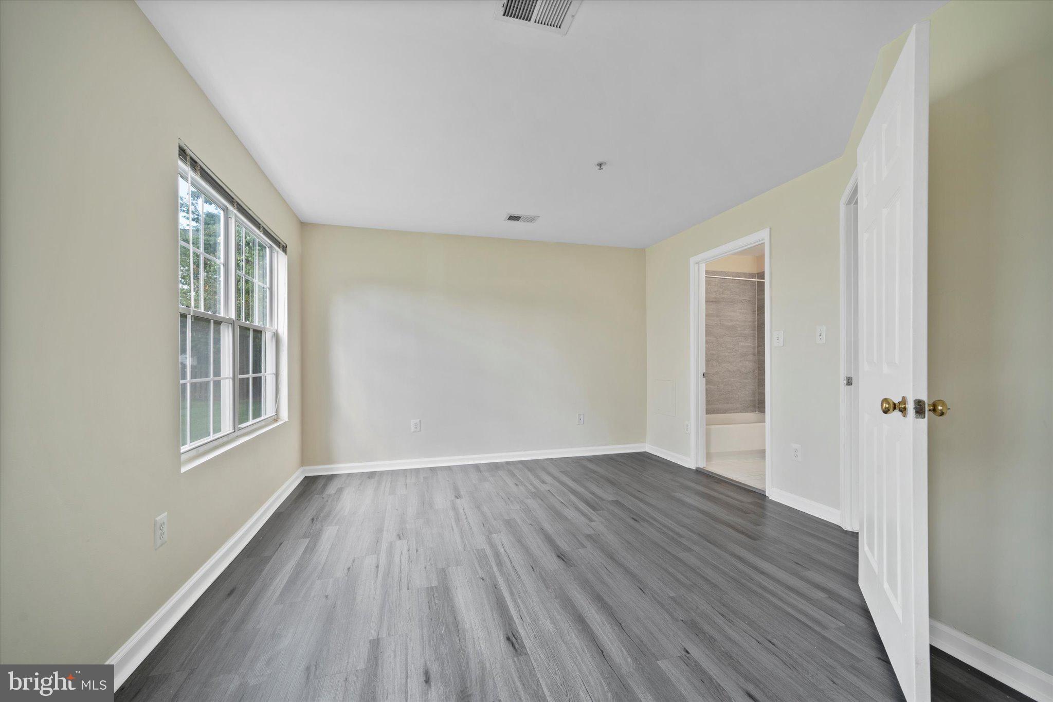 8083 Lacy Drive, Unit 101 Manassas, VA 20109 - Photo 16 of 31 a view of an empty room with wooden floor and a window