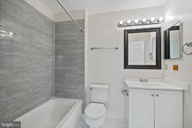 a bathroom with a toilet a sink a mirror and bathtub