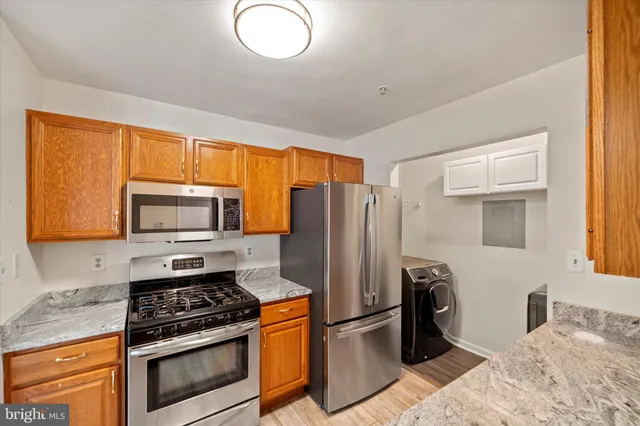 a kitchen with stainless steel appliances granite countertop a stove a refrigerator and a microwave