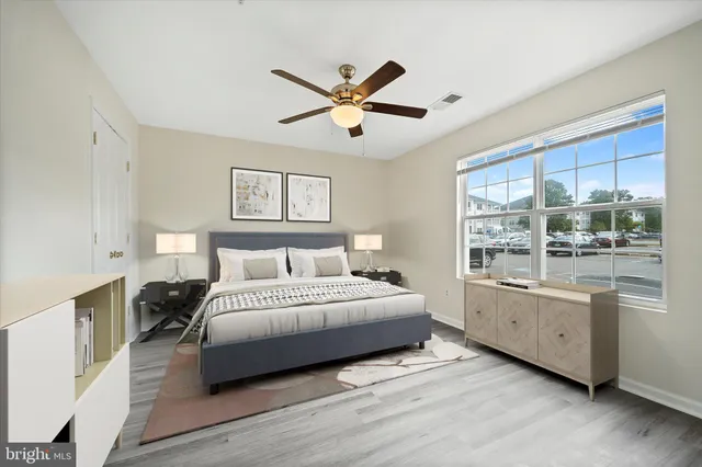 a spacious bedroom with a large bed and a chandelier fan