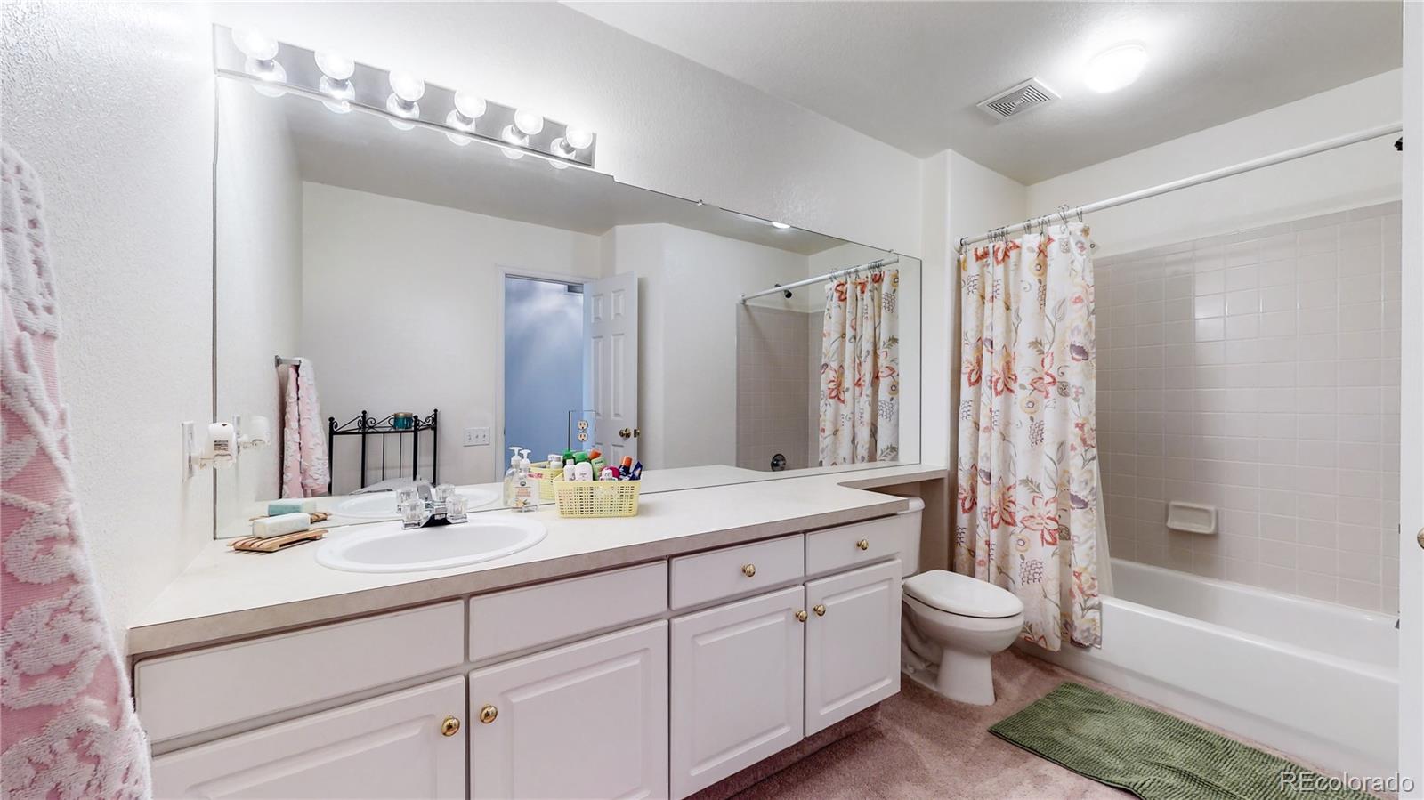 10105 North Grove Loop, Unit A Westminster, CO 80031 - Photo 19 of 40 a bathroom with a double vanity sink toilet mirror and bathtub