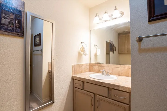 a bathroom with a sink vanity and a mirror