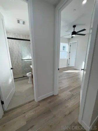 an empty room with wooden floor a ceiling fan and a window