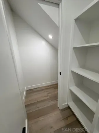 a view of hallway with window and wooden floor