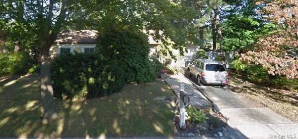 a backyard of a house with large trees and plants