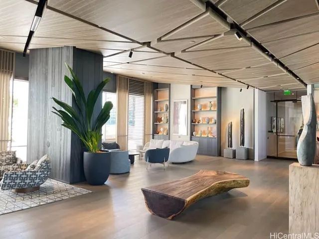 a living room with furniture flowerpot and wooden floor