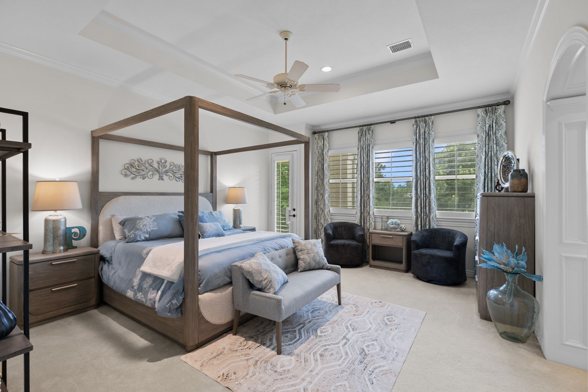 39 Maymont Way Spring, TX 77382 - Photo 33 of 50 This spacious bedroom features a stylish canopy bed, elegant decor, and abundant natural light from large windows with drapes. It includes cozy seating, a ceiling fan, and neutral tones for a serene atmosphere. Perfect for relaxation.