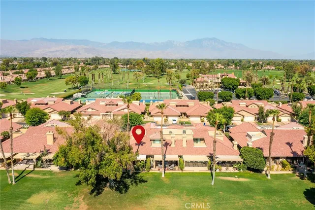 an aerial view of residential houses with outdoor space and trees