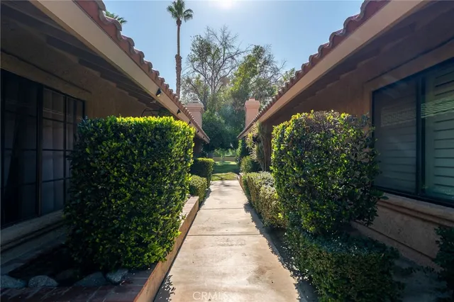 a backyard of a house with table and chairs and potted plants