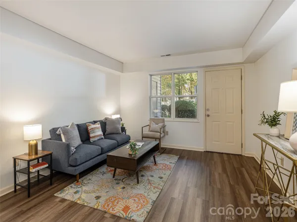 a living room with furniture and a wooden floor