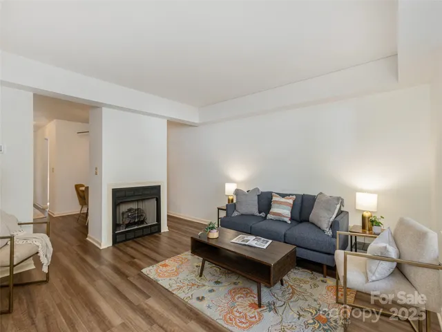 a living room with furniture a fireplace and a wooden floor