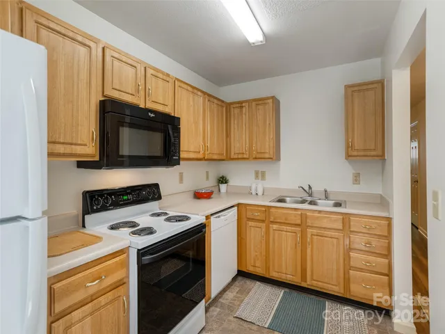 a kitchen with stainless steel appliances a sink a stove cabinets and a window