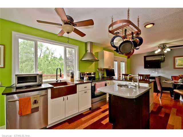 a kitchen with a large window cabinets a sink and stainless steel appliances