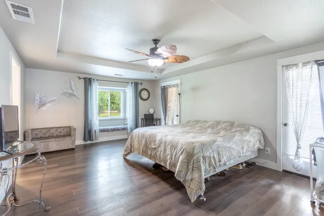a bed sitting in a spacious bedroom next to a window