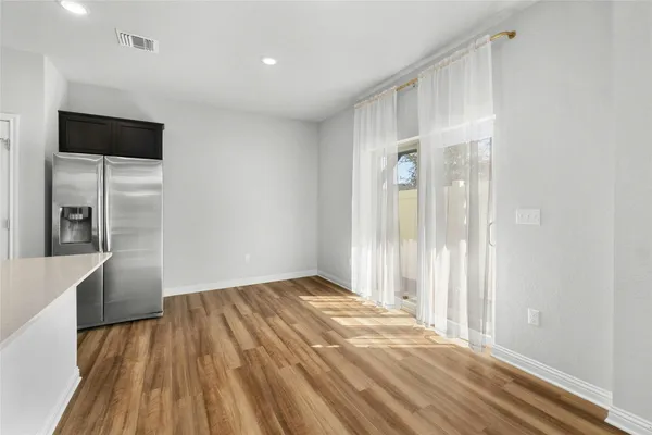 a view of a livingroom with wooden floor and a hallway