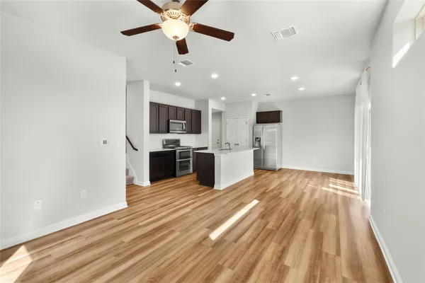 a view of a kitchen with a sink and dishwasher a refrigerator with wooden floor