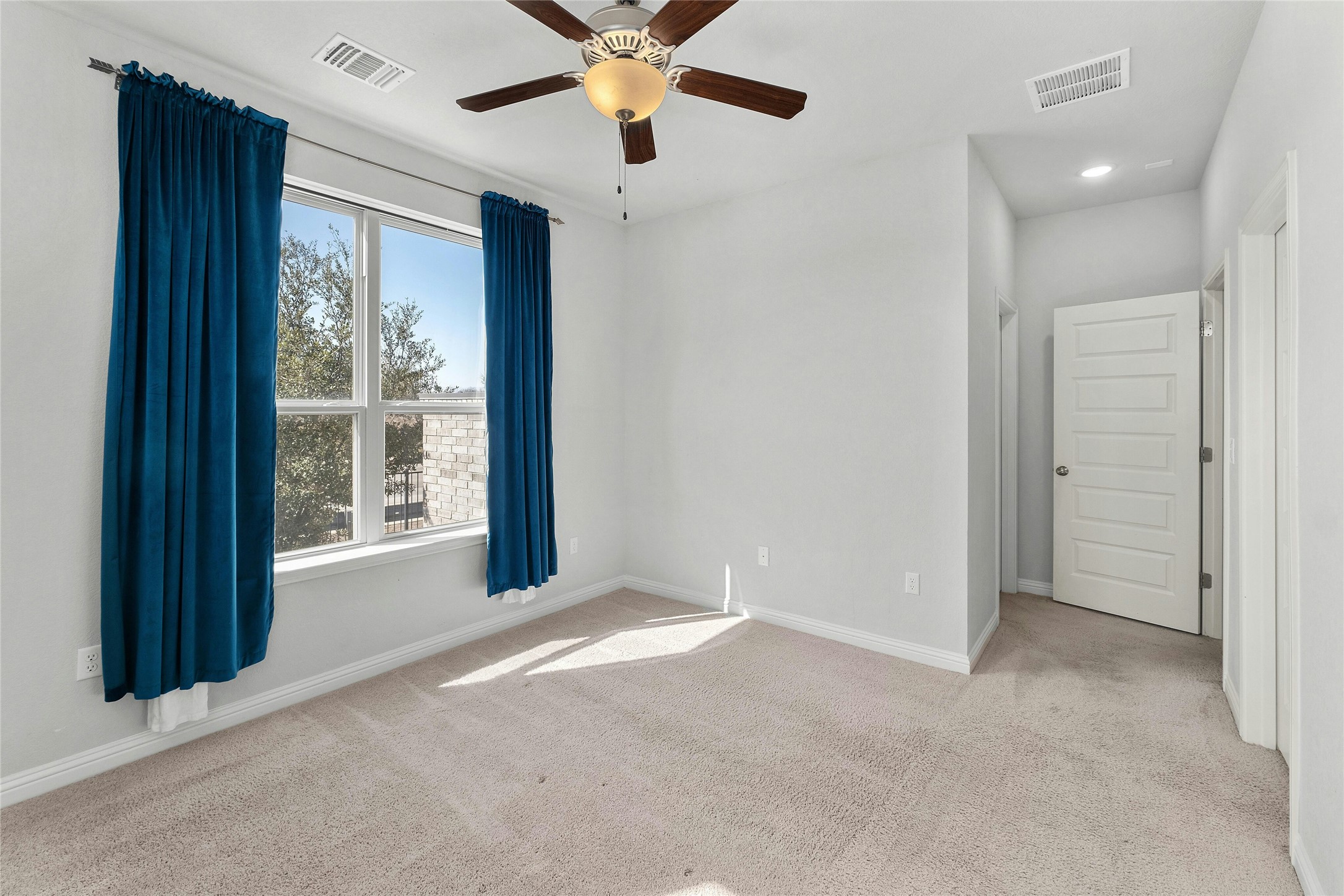 8101 Frida Bend Austin, TX 78744 - Photo 13 of 30 Spare room featuring a ceiling fan, light carpet, and recessed lighting