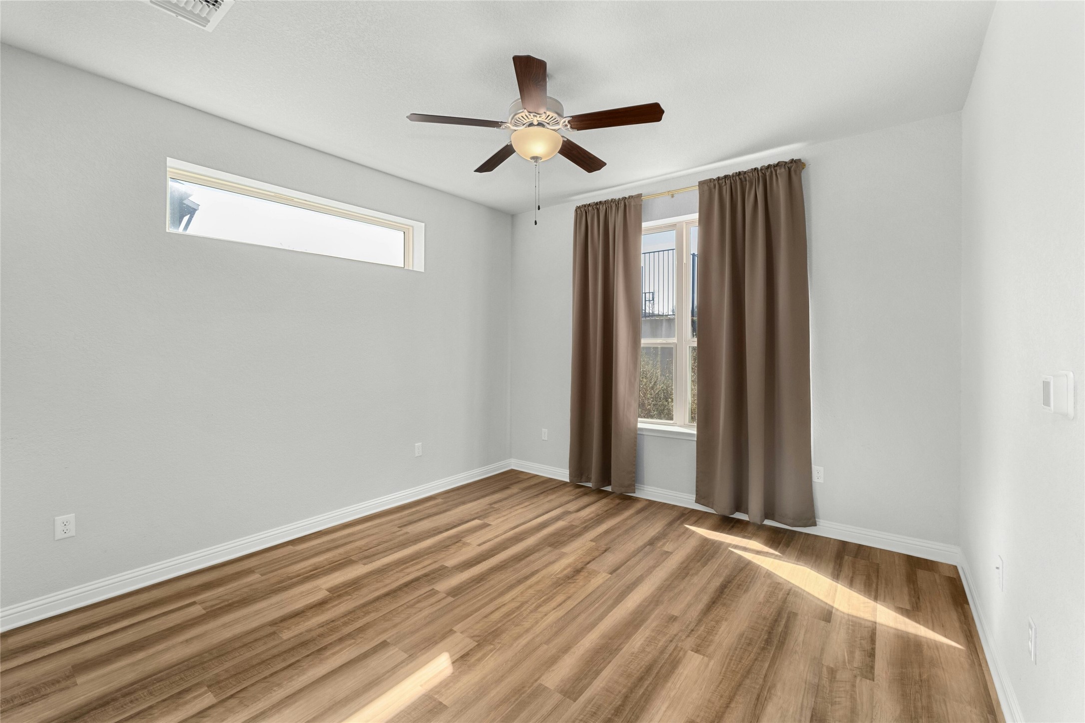 8101 Frida Bend Austin, TX 78744 - Photo 20 of 30 Empty room featuring ceiling fan, healthy amount of natural light, and light wood-style flooring