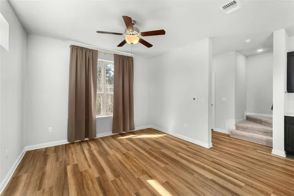 a view of empty room with wooden floor