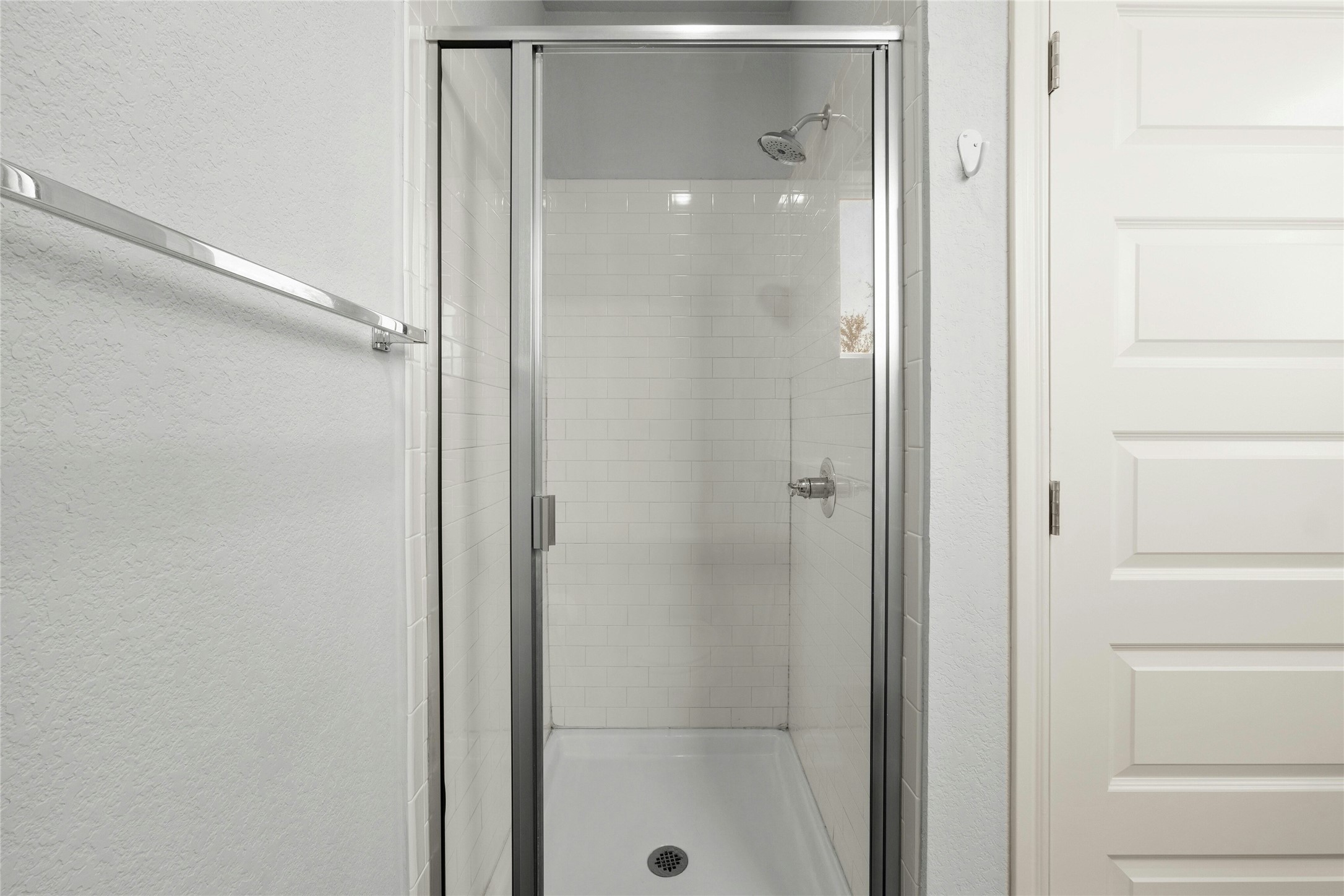 8101 Frida Bend Austin, TX 78744 - Photo 23 of 30 Bathroom with a textured wall and a shower stall