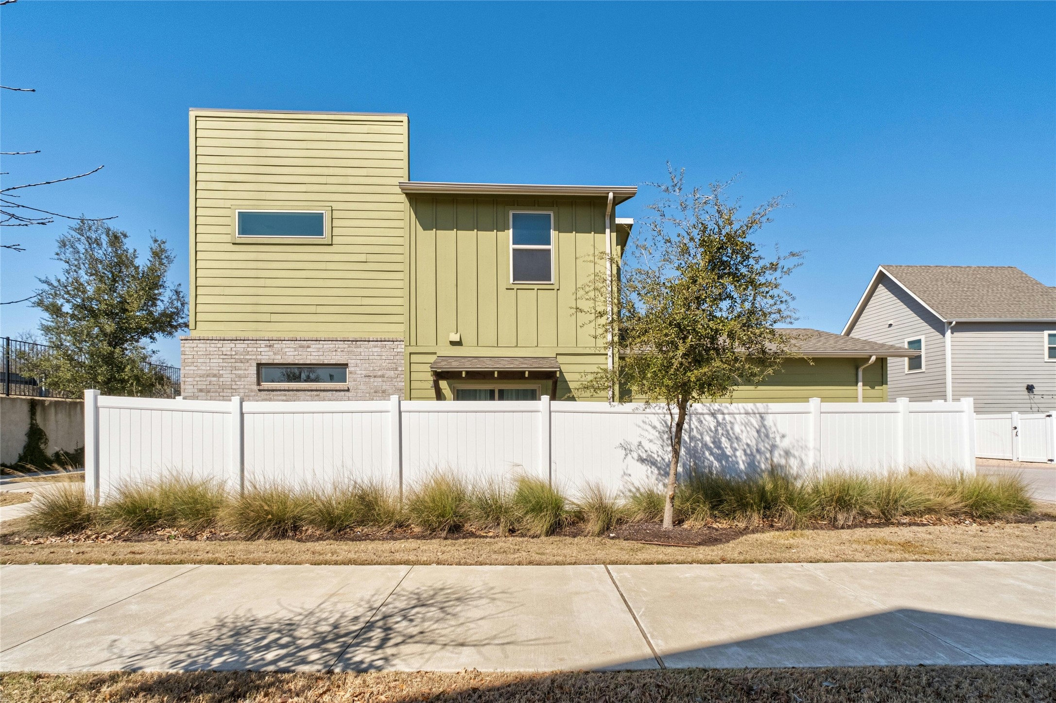 8101 Frida Bend Austin, TX 78744 - Photo 5 of 30 View of side of property featuring board and batten siding and brick siding