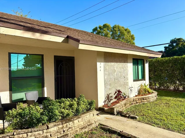 a front view of a house with lots of potted plants