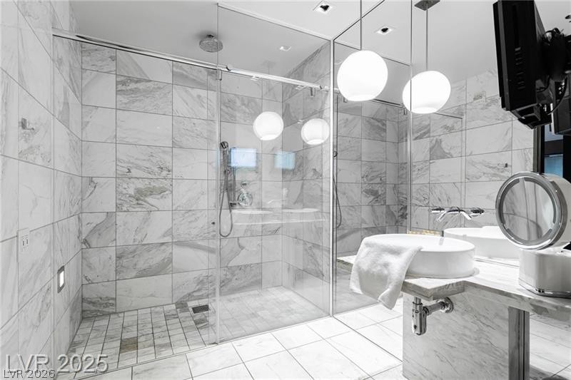 4381 West Flamingo Road, Unit 1809 Las Vegas, NV 89103 - Photo 7 of 11 Bathroom featuring a shower stall and tile walls