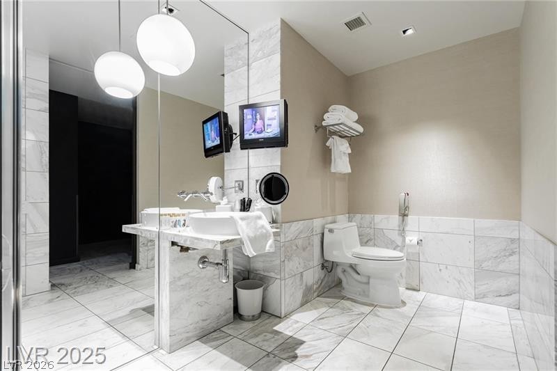 4381 West Flamingo Road, Unit 1809 Las Vegas, NV 89103 - Photo 8 of 11 Bathroom with tile walls and toilet