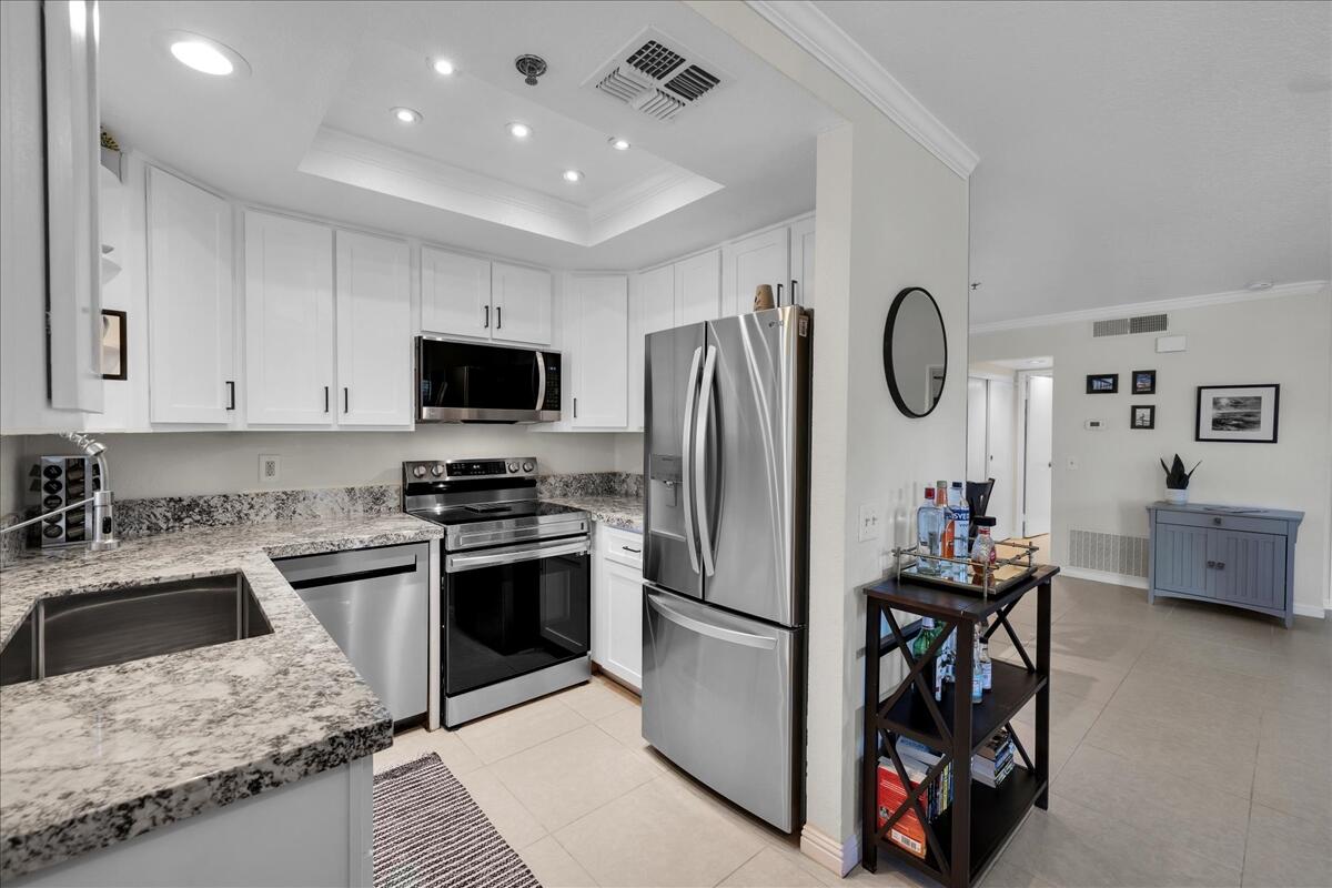 2700 Lawrence Crossley Road, Unit 83 Palm Springs, CA 92264 - Photo 12 of 52 a kitchen with stainless steel appliances granite countertop a stove top oven a sink dishwasher a refrigerator and a dining table with the kitchen view