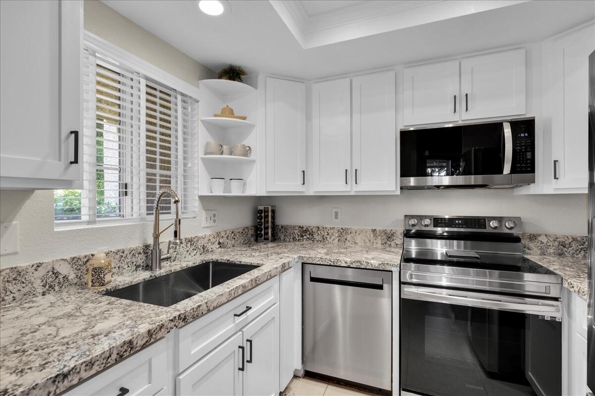 2700 Lawrence Crossley Road, Unit 83 Palm Springs, CA 92264 - Photo 16 of 52 a kitchen with granite countertop white cabinets and white appliances