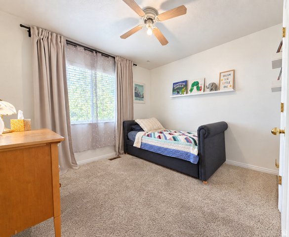 452 North 600 East Springville, UT 84663 - Photo 15 of 26 Neutral-toned wall-to-wall carpeting, window with blinds and sheer curtains, ceiling fan with light fixture, and wall-mounted shelving