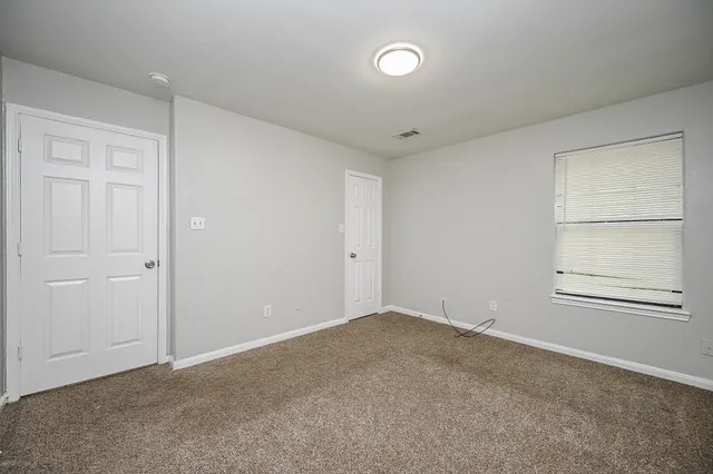 an empty room with windows and closet