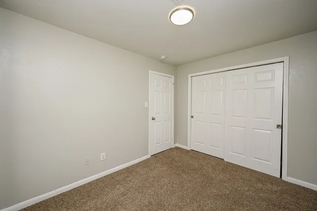 an empty room with windows and closet