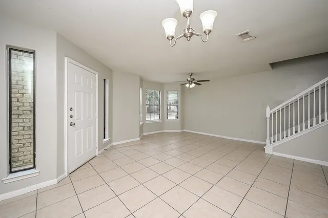an empty room with chandelier fan