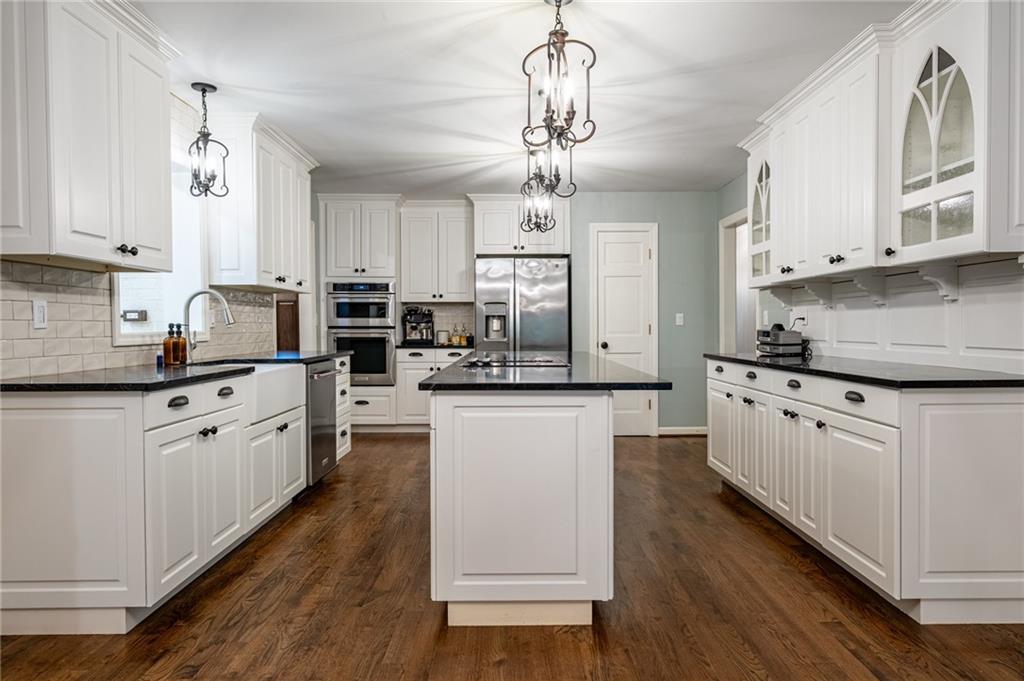 4067 Mason Creek Road Winston, GA 30187 - Photo 16 of 48 a kitchen with stainless steel appliances granite countertop a refrigerator a stove top oven a sink dishwasher and white cabinets with wooden floor