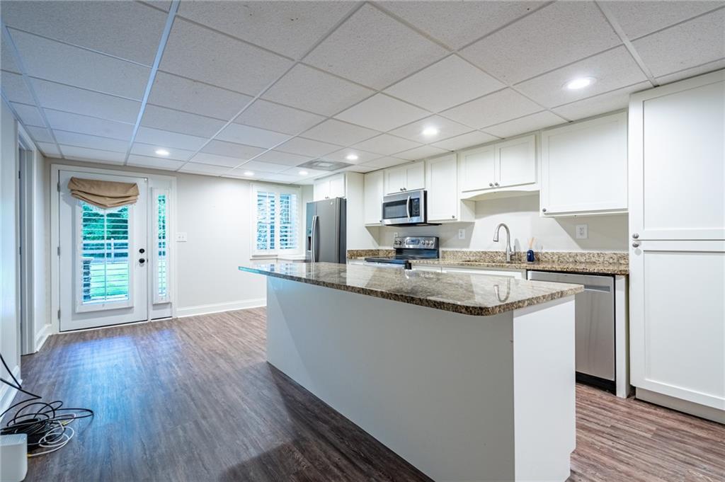 4067 Mason Creek Road Winston, GA 30187 - Photo 34 of 48 a kitchen with granite countertop a sink cabinets and wooden floor