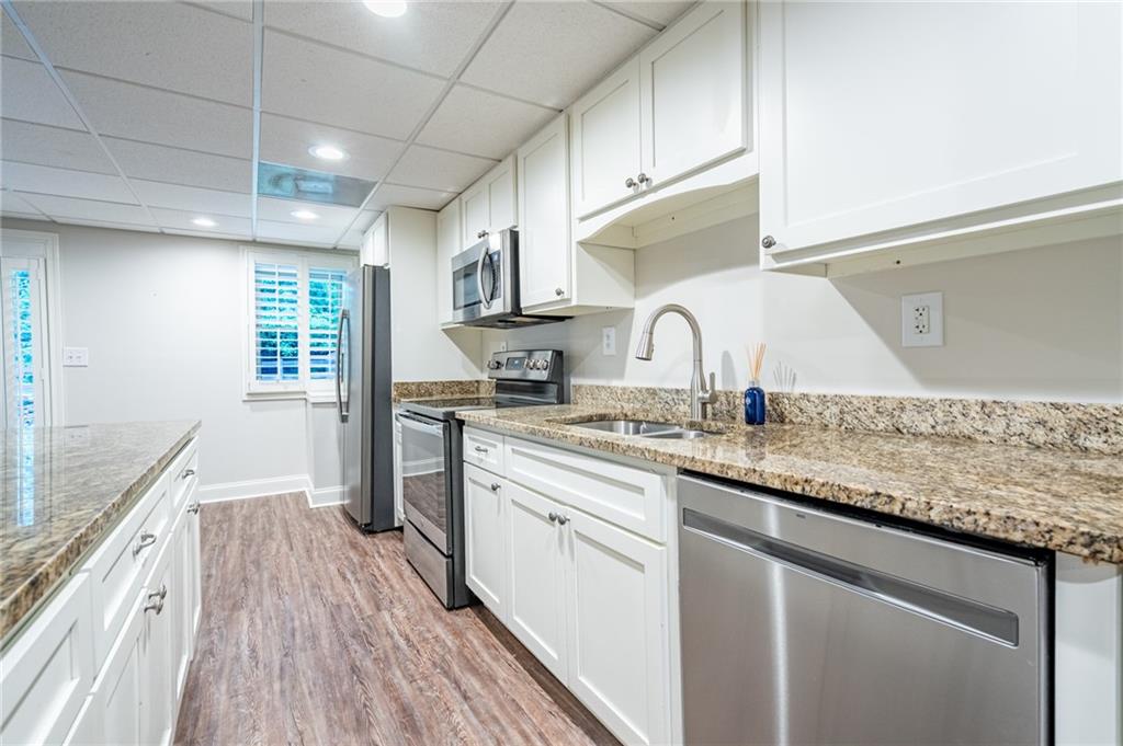 4067 Mason Creek Road Winston, GA 30187 - Photo 35 of 48 a kitchen with granite countertop a sink cabinets wooden floor and stainless steel appliances