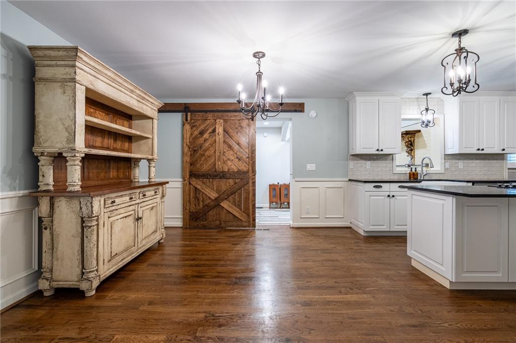 4067 Mason Creek Road Winston, GA 30187 - Photo 6 of 48 a kitchen with stainless steel appliances granite countertop a refrigerator a stove and white cabinets with wooden floors