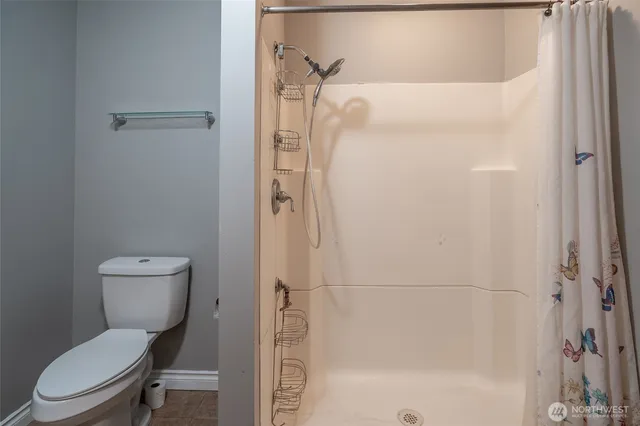 a bathroom with a toilet and a shower