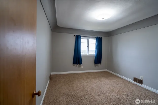 a view of a livingroom with wooden floor and a bathroom