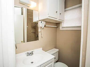 4309 42nd Street Lubbock, TX 79413 - Photo 11 of 21 a bathroom with a sink a toilet and shower