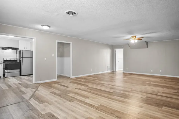 a view of a room with wooden floor and a ceiling fan