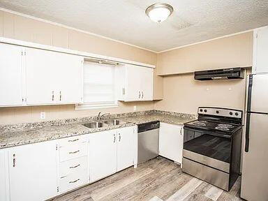 4309 42nd Street Lubbock, TX 79413 - Photo 7 of 21 a kitchen with a stove a sink and a refrigerator