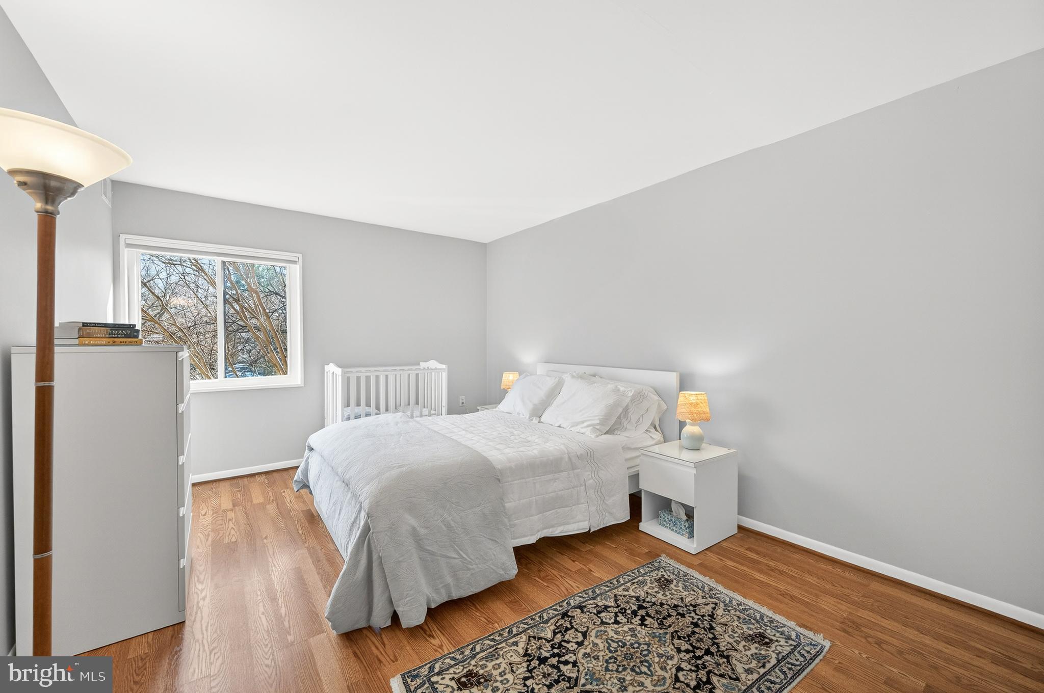 1536 Northgate Square, Unit 21 Reston, VA 20190 - Photo 14 of 50 a bedroom with a bed and wooden floor