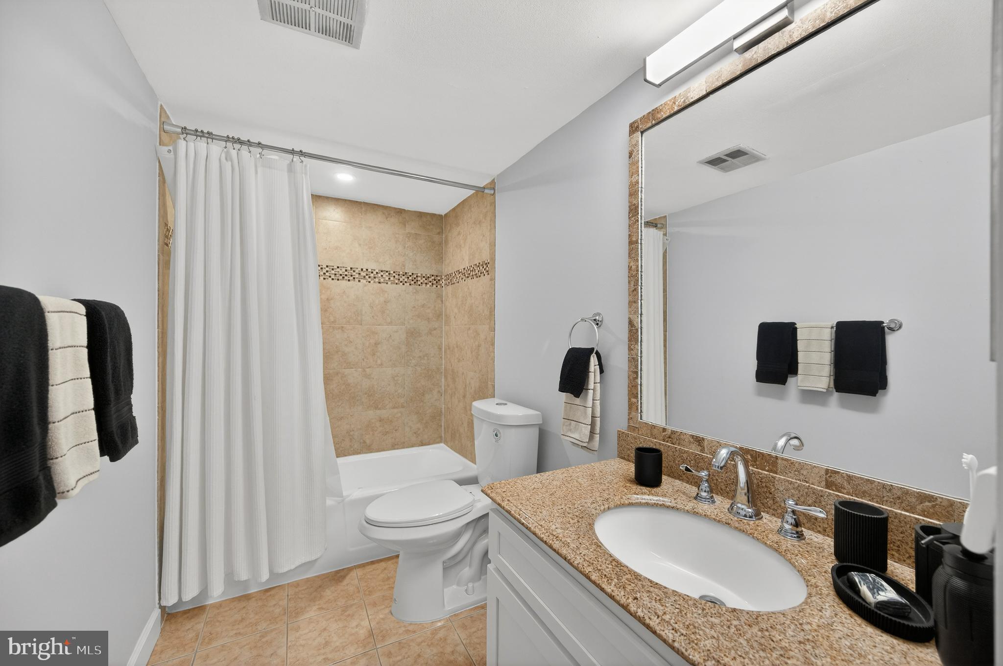 1536 Northgate Square, Unit 21 Reston, VA 20190 - Photo 5 of 50 a bathroom with a granite countertop sink toilet a mirror a bathtub and shower