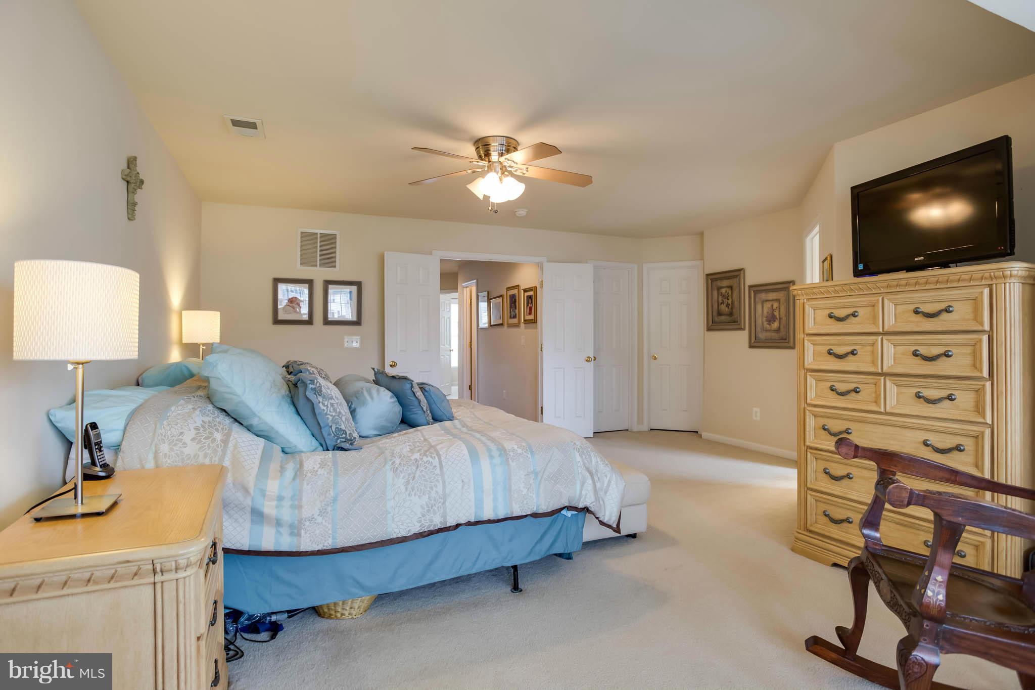 2242 Henry Watts Loop Woodbridge, VA 22191 - Photo 15 of 30 a bedroom with a bed and a flat screen tv