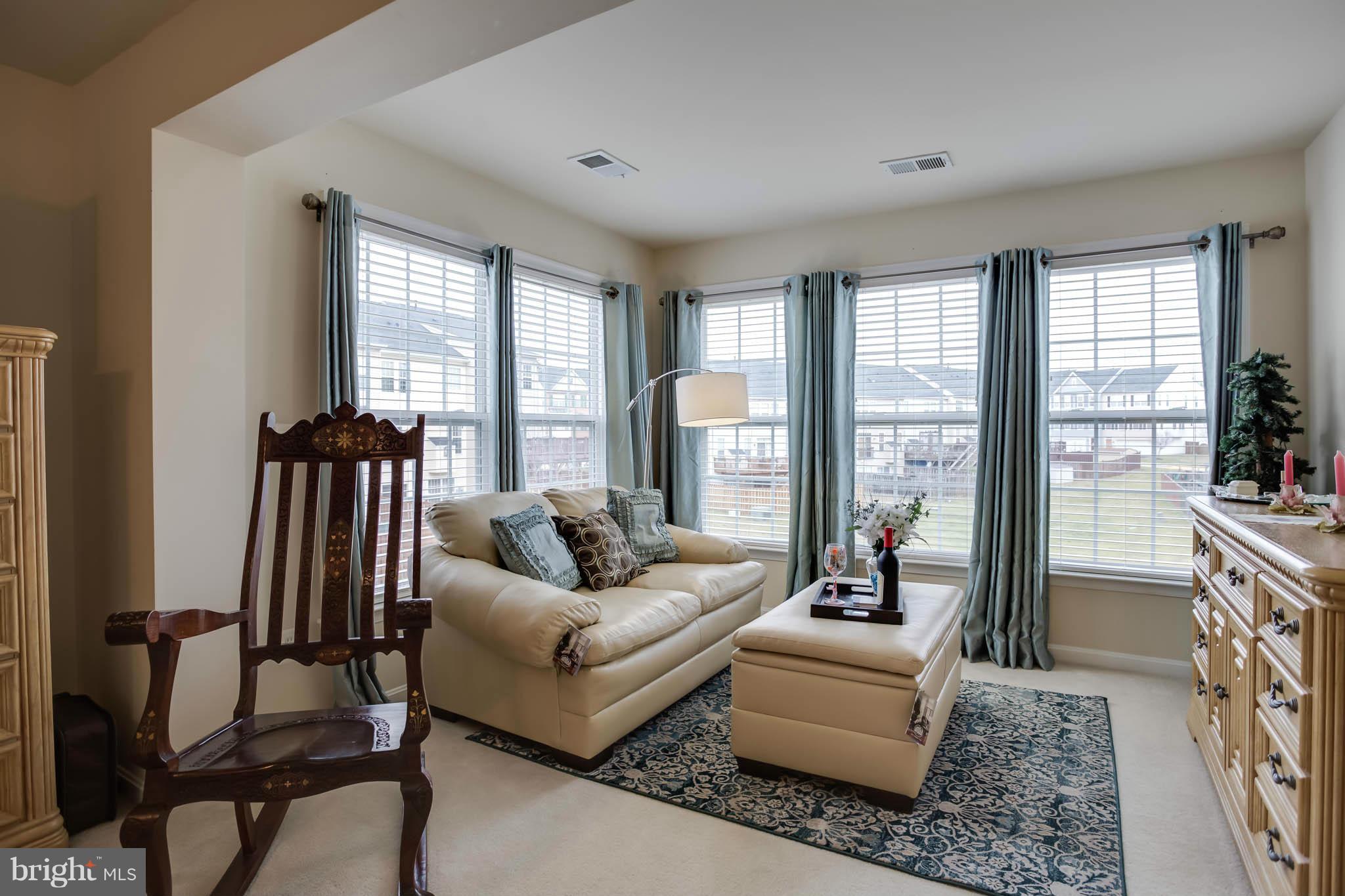 2242 Henry Watts Loop Woodbridge, VA 22191 - Photo 16 of 30 a living room with furniture and floor to ceiling windows