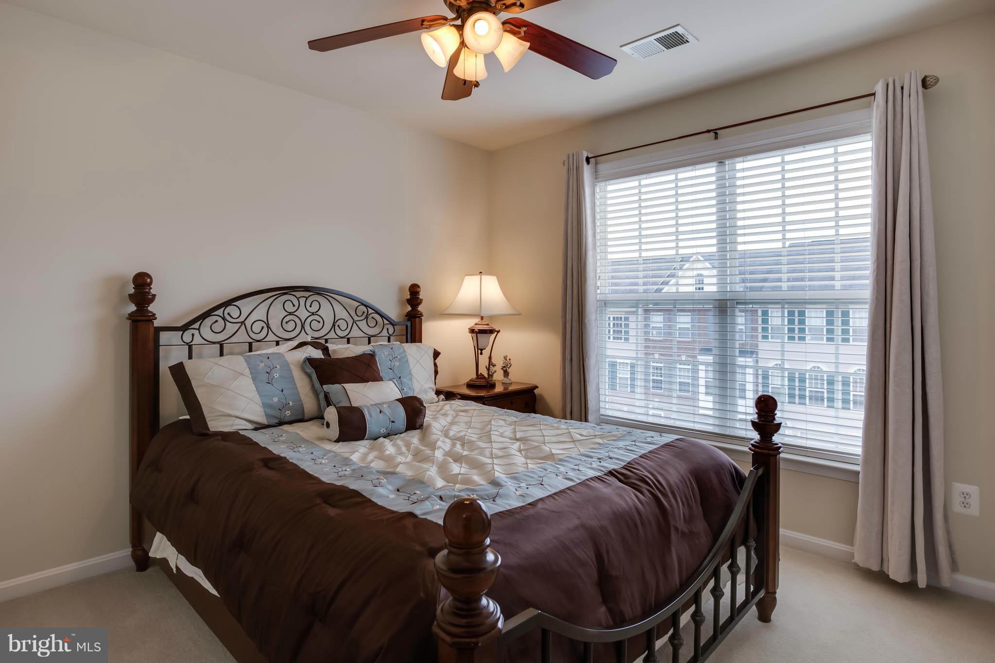 2242 Henry Watts Loop Woodbridge, VA 22191 - Photo 19 of 30 a bed sitting in a bedroom next to a window